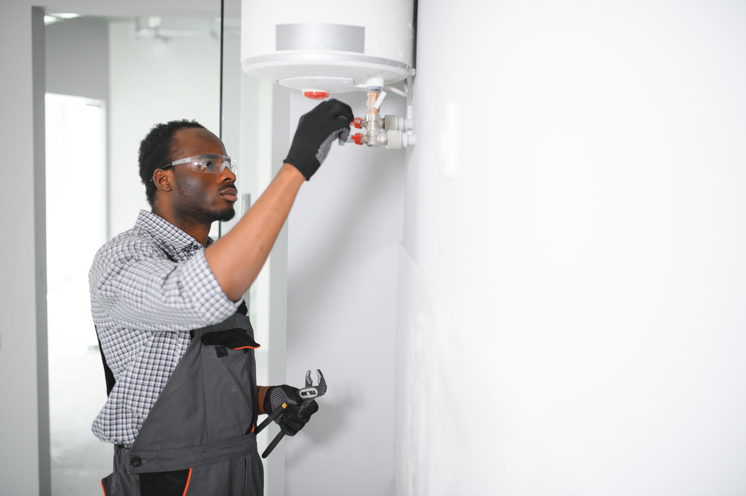 Professional african american engineer doing a boiler inspection at home